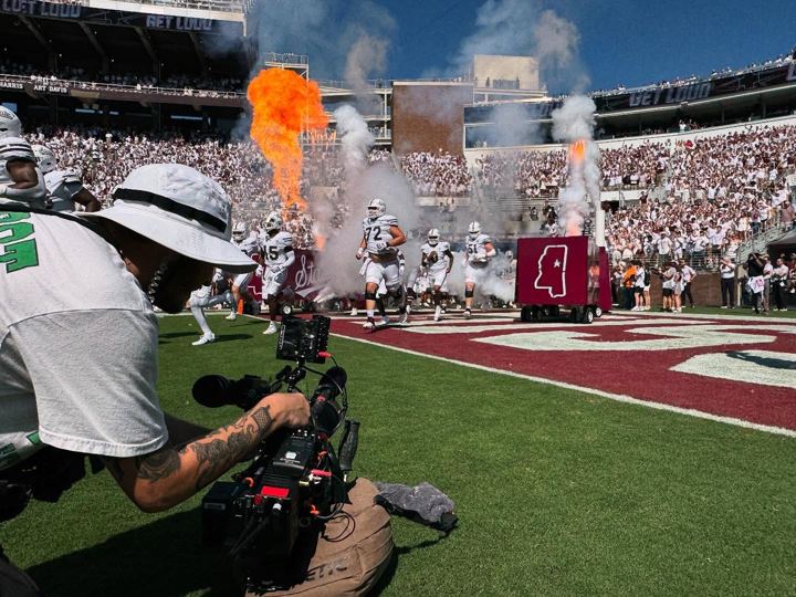 Shooting the sideline as an SEC team runs out through pyro