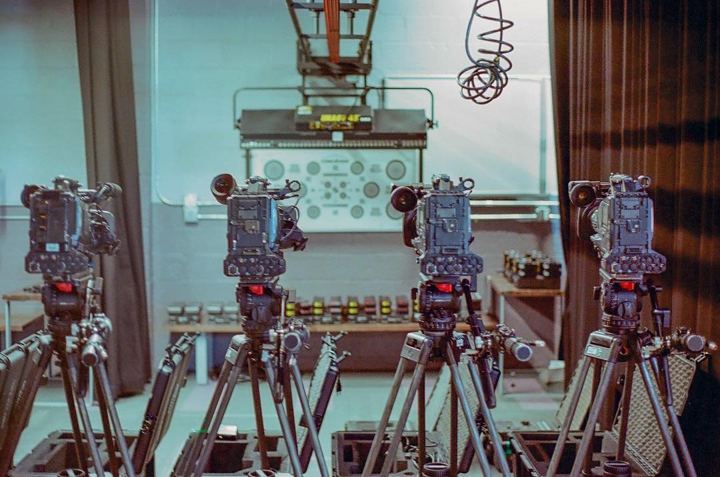 Camera bodies lined up on tripods in a church