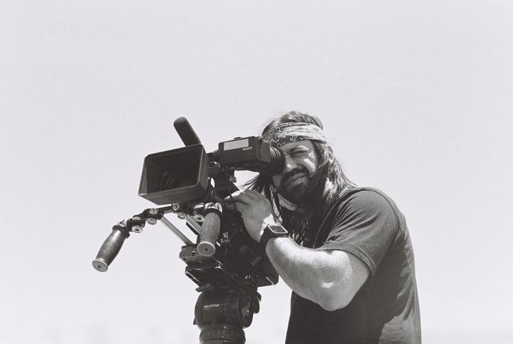 Camera operator with a shoulder rig on white