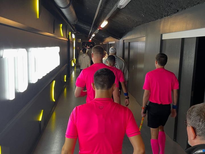 Referees walking the tunnel in pink
