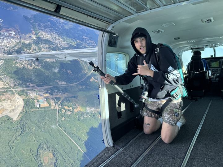 Riding the open door of a jump plane with a pole cam