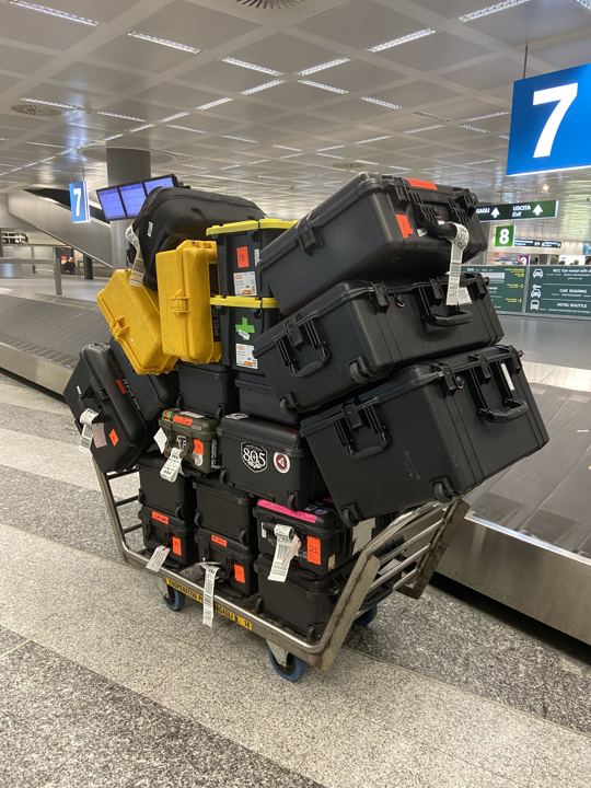 Cart stacked with camera cases at the airport